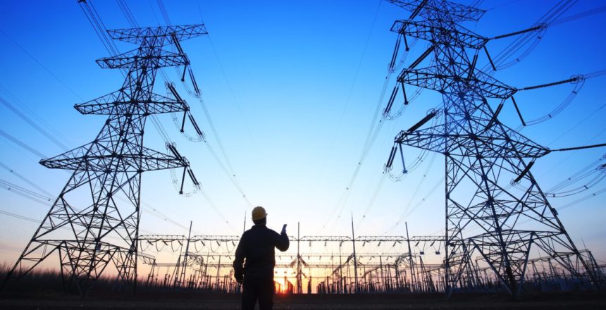 In the evening, electricity workers and pylon silhouette